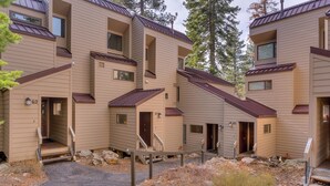 A multi-story building with a symmetrical facade, multiple balconies, and a central courtyard with steps leading to the entrance. - Livin' Lodge: 3  BR, 2  BA Townhouse in Carnelian Bay, Sleeps 8 (Carnelian Bay)