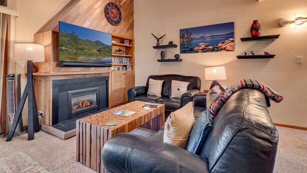 A cozy living room with a fireplace, leather sofa, and a flat-screen TV. - Livin' Lodge: 3  BR, 2  BA Townhouse in Carnelian Bay, Sleeps 8 (Carnelian Bay)