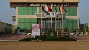 Un edificio de varios pisos con un letrero llamativo que dice "ARMADA HOTEL".