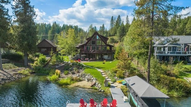 A lakeside lodge with a dock, red chairs, and a boat. - Waterfront Log Home, Dock, Hot Tub, and Pickleball (Sagle)