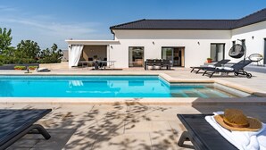A modern house with a swimming pool, outdoor furniture, and a covered patio area. - Villa Lukas with 4 bedrooms, a high-quality family property in the Makarska hinterland (Gornji Vinjani)
