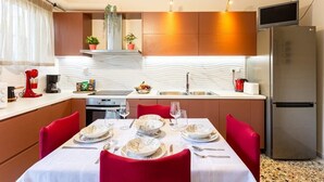 Une cuisine moderne avec un coin repas, équipée d’un réfrigérateur, d’un four à micro-ondes et d’une machine à café.