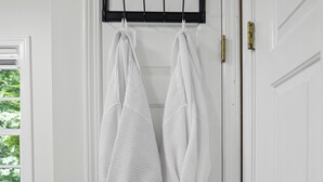 Une porte blanche avec un porte-serviettes sur lequel sont accrochées deux serviettes blanches.