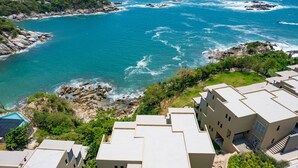 A coastal hotel with multiple buildings, a rocky shoreline, and a view of the ocean. - Private Oceanview Splash Pool & Beach Access (Huatulco)