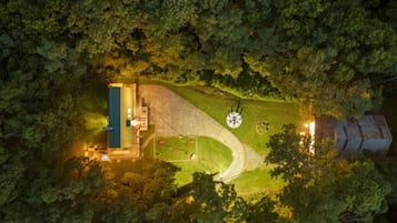 An aerial view of a property with a large building, a circular structure, and a well-maintained lawn.