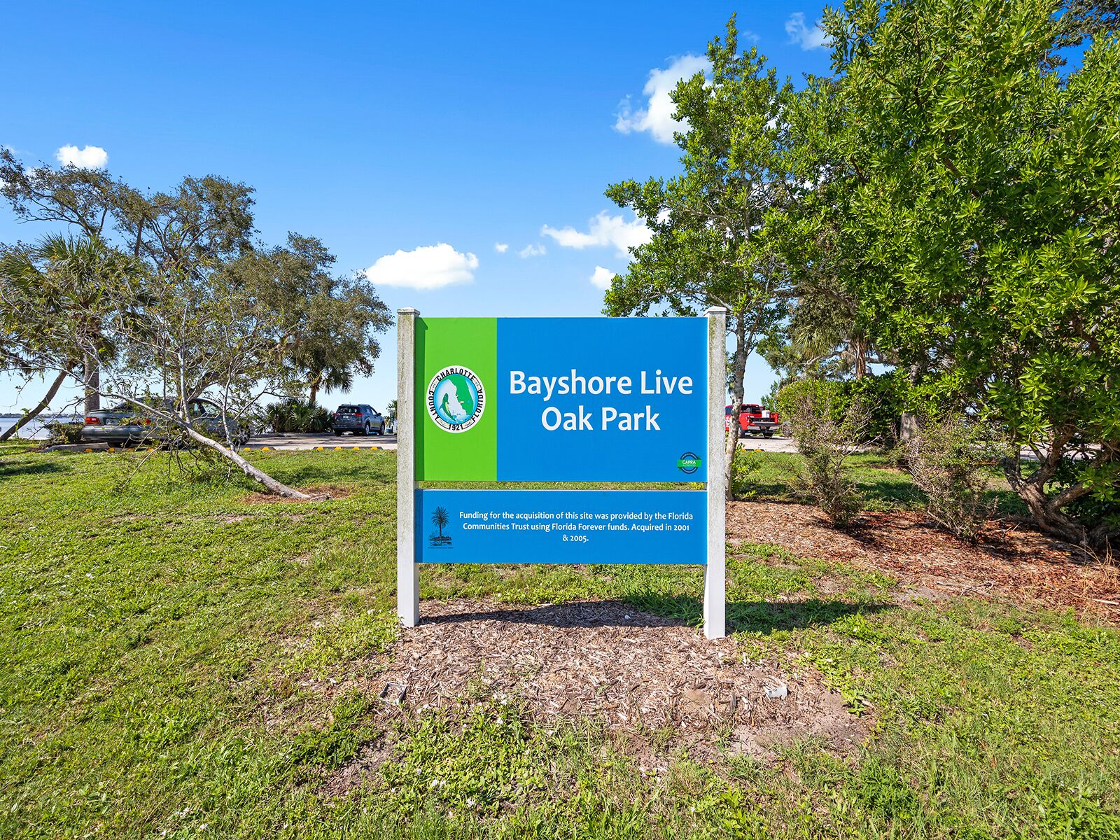 Un panneau indiquant l'entrée du parc Bayshore Live Oak, avec une palette de couleurs verte et bleue.