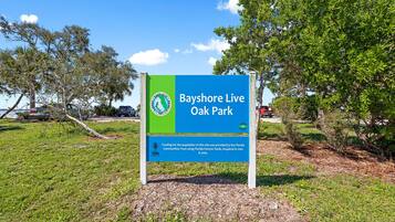 Un panneau indiquant l'entrée du parc Bayshore Live Oak, avec une palette de couleurs verte et bleue.