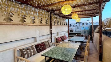Un espacio al aire libre con muebles de madera y faroles colgantes.