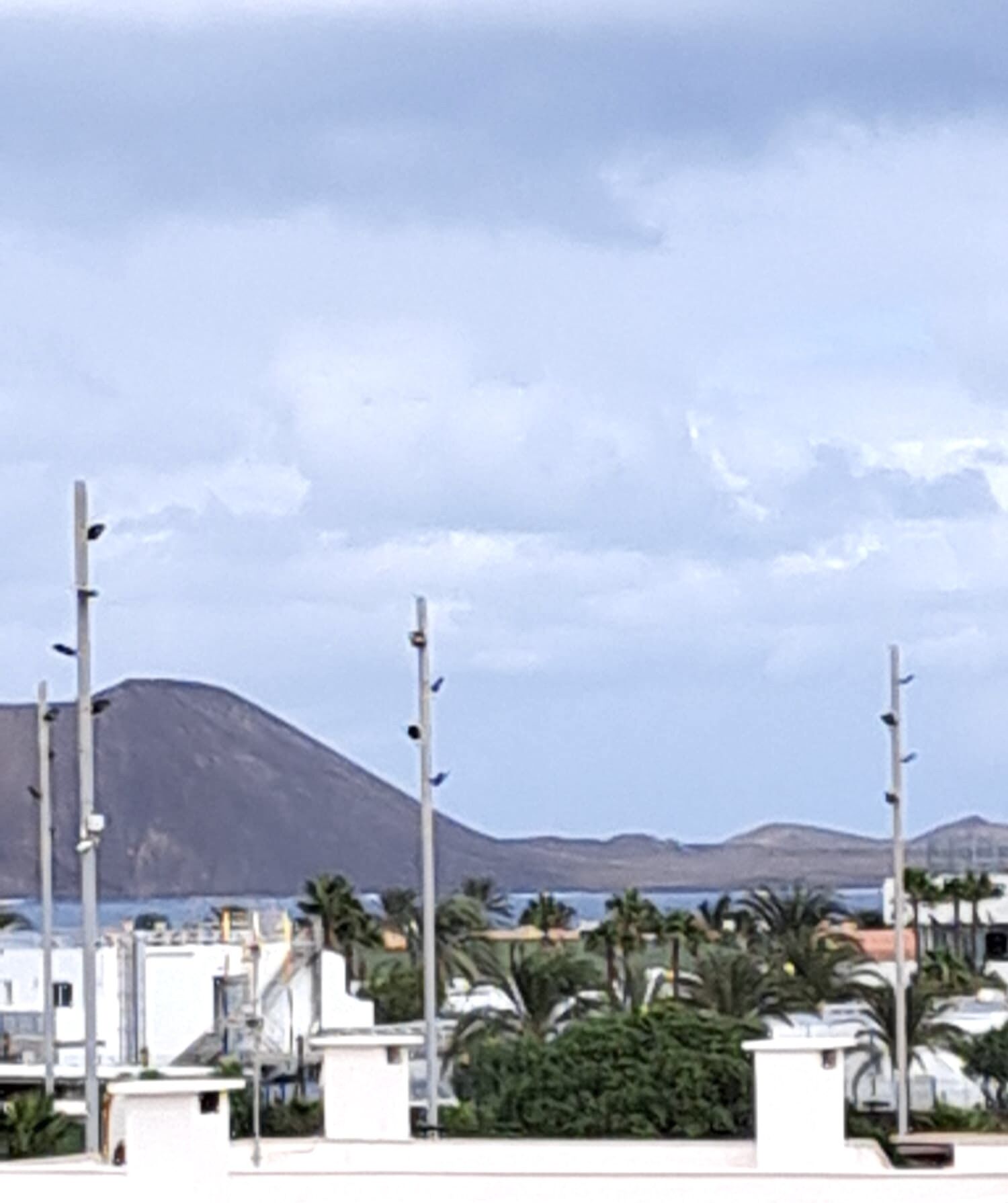 Un quartier résidentiel avec des bâtiments modernes, des lampadaires et une montagne en arrière-plan.