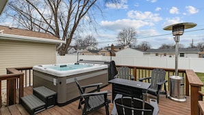 Eine Terrasse mit Whirlpool, Sitzgelegenheit und Terrassenheizung.
