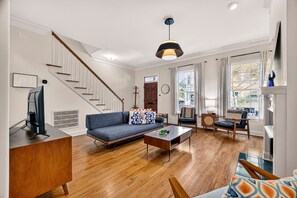 Un salon avec un canapé, une table basse et un escalier.
