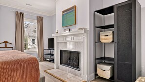 A modern room with a fireplace, a bed, a TV, and a large wardrobe.