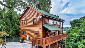 A log cabin with a balcony, surrounded by trees. - Beautiful & Cozy Amazing Views, Games rm! (Sevierville)