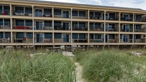Un motel de varios pisos con balcones, cerca de un área verde.