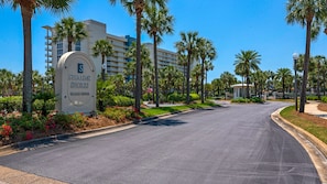 Sterling Shores with a clear road, palm trees, and a sign indicating vacation rentals.