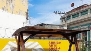 A wooden swing chair with a yellow wall in the background. - Aldeia Hostel II (Manaus)