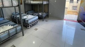 A dormitory room with bunk beds, a painting on the wall, and a tiled floor. - Aldeia Hostel II (Manaus)