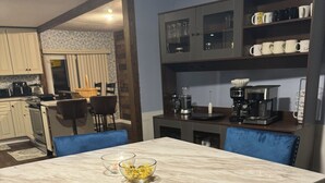 A dining area with a marble table and blue upholstered chairs.