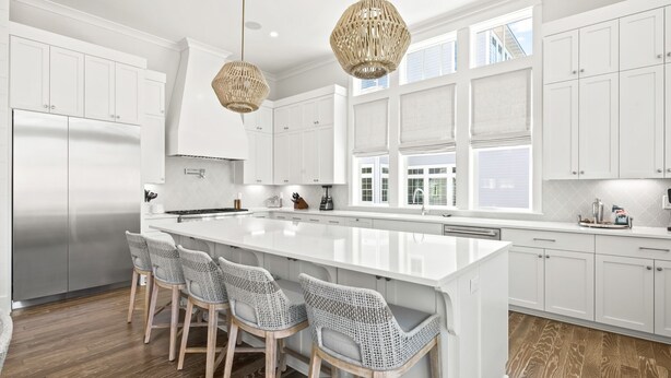A modern kitchen with white cabinetry, a large island with bar stools, and pendant lighting. - Walk to Seaside! Luxury 6BR w/ Private Pool, Golf Cart & Elevator | Sleeps 20 (Santa Rosa Beach)