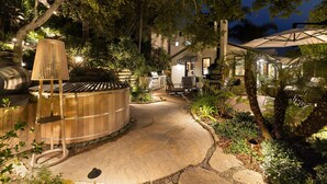 A stone pathway leading to a wooden hot tub, surrounded by lush greenery and a patio area with outdoor furniture. - Montecito Bungalow-walking distance to lower village! (Montecito)