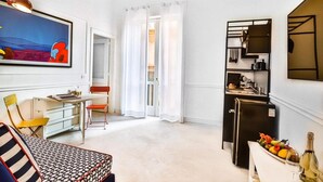 A compact living space with a dining area, a kitchenette, and a view through a doorway. - Iommella Luxury Flat - Adami (Sant'Agnello)