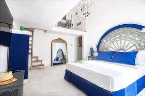 A bedroom with a large bed, a staircase, a balcony, and a decorative mirror. - Iommella Luxury Flat - Adami (Sant'Agnello)