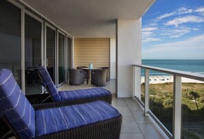 A balcony with a view of the beach, a table with chairs, and a sofa. - Marriott's Crystal Shores...The Perfect Getaway in this Luxurious 2 Bedroom (Marco Island)