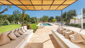 Un espacio de estar al aire libre cubierto con una piscina al fondo.