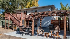 A patio with wooden furniture and a pergola structure.