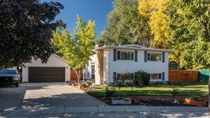 A single-story house with a garage, a driveway, and a well-maintained lawn.