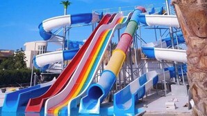 A water park with multiple slides and a palm tree. - Chalet for rent in fanadir bay resort  (Hurghada)