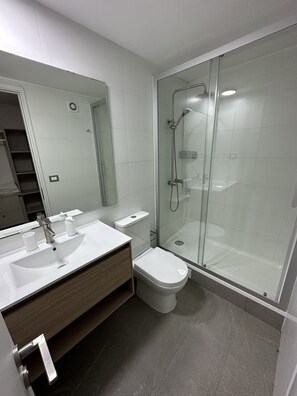 Chuveiro, toalhas de banho, sabonete, papel higiênico