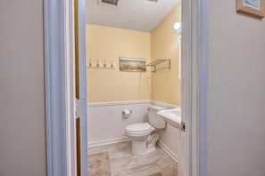Une salle de bain comprenant des toilettes, un lavabo et un espace douche.
