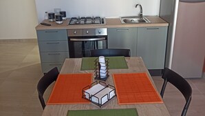 Une cuisine moderne avec des meubles gris, une cuisinière en acier inoxydable et un évier.