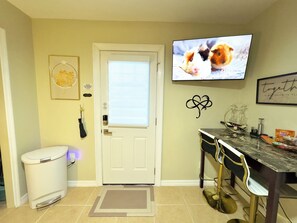 Un bureau à domicile équipé d’un bureau, d’une chaise et d’un téléviseur sur lequel on peut voir un chat.
