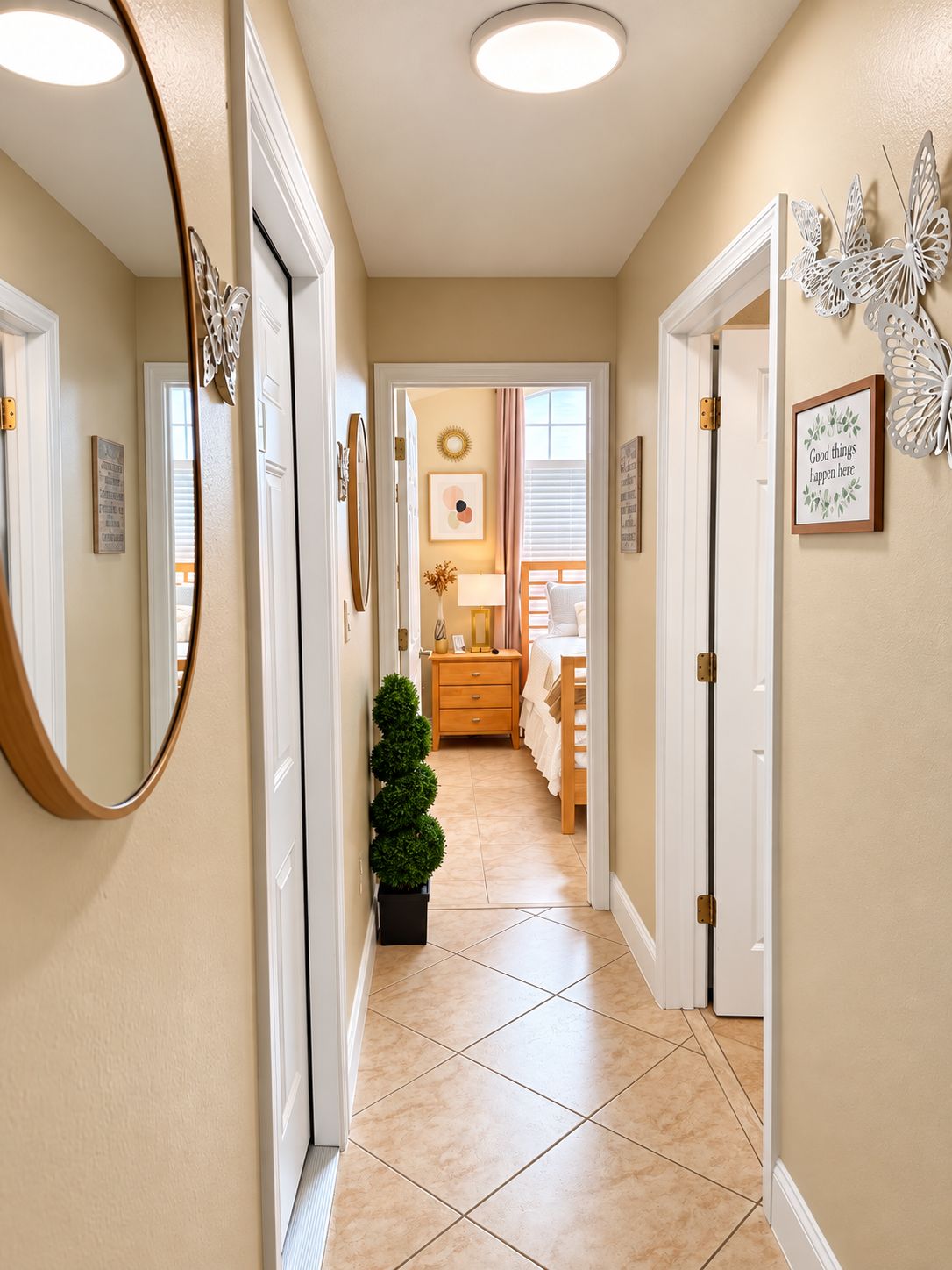 A hallway with a mirror, a small potted plant, a bed, and a wall with a decorative butterfly.