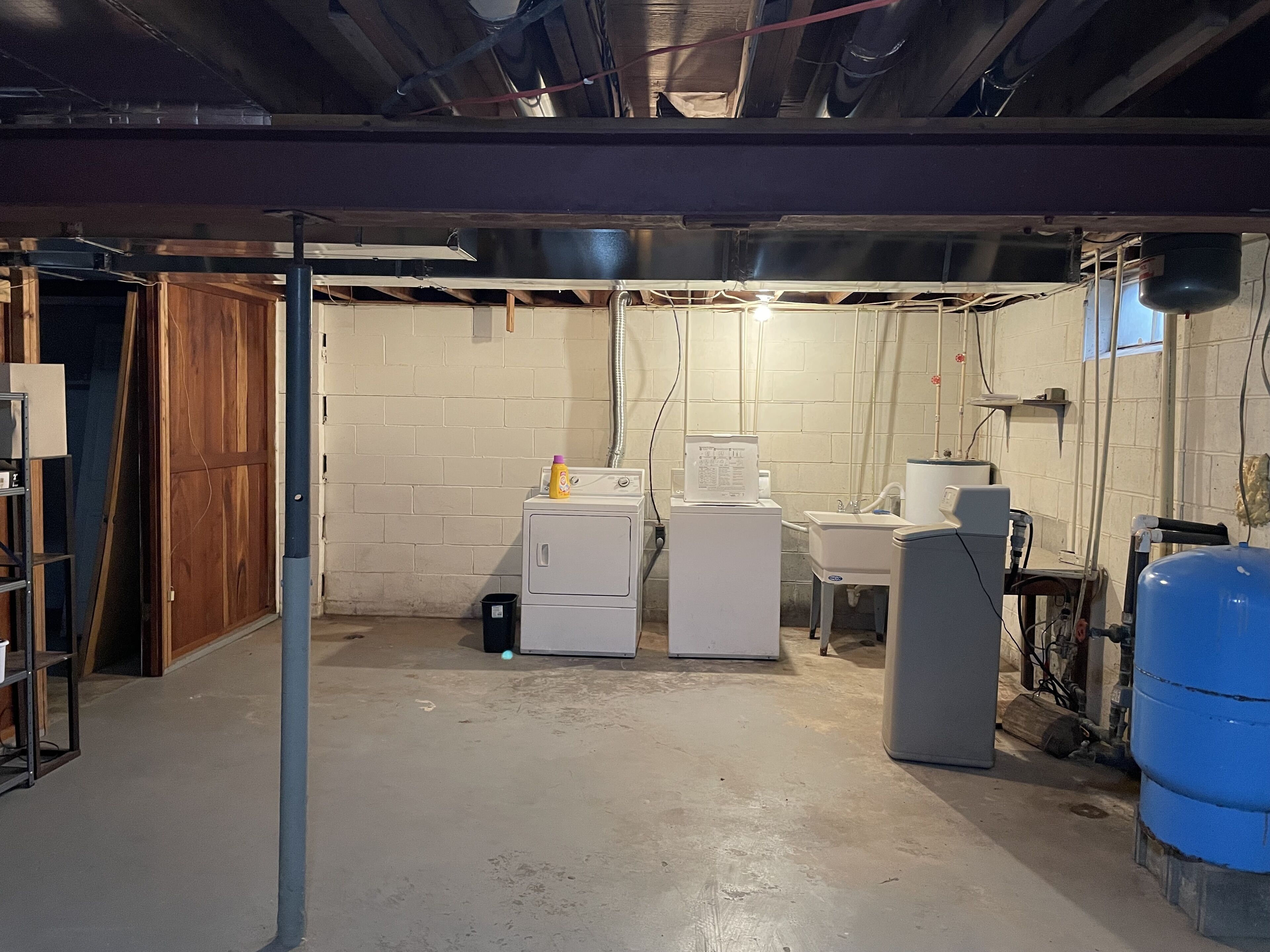A laundry room with a washing machine, dryer, sink, and water heater.