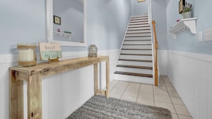 A staircase with wooden steps and a white railing, leading to an upper floor. - Sunset Horizon | Private Fenced-in Backyard | Surf City! (surf ctiy)