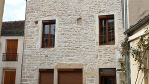 Un edificio de piedra con una puerta de garaje, un ventanal pequeño y una puerta.