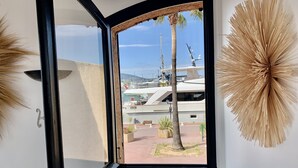 Una habitación con un amplio ventanal con vista a un puerto deportivo y yates.