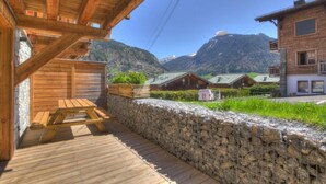 A wooden deck with a stone wall and a wooden bench. - 200m from ski slopes, Ground floor, terrace, tv, 42m², Morzine (Morzine)