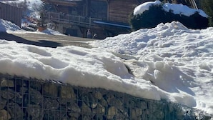 A wooden cabin with a sloped roof, surrounded by snow and a stone wall. - 200m from ski slopes, Ground floor, terrace, tv, 42m², Morzine (Morzine)
