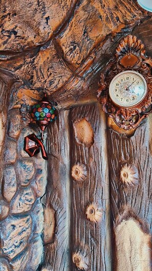 A wooden wall with a clock and decorative elements.