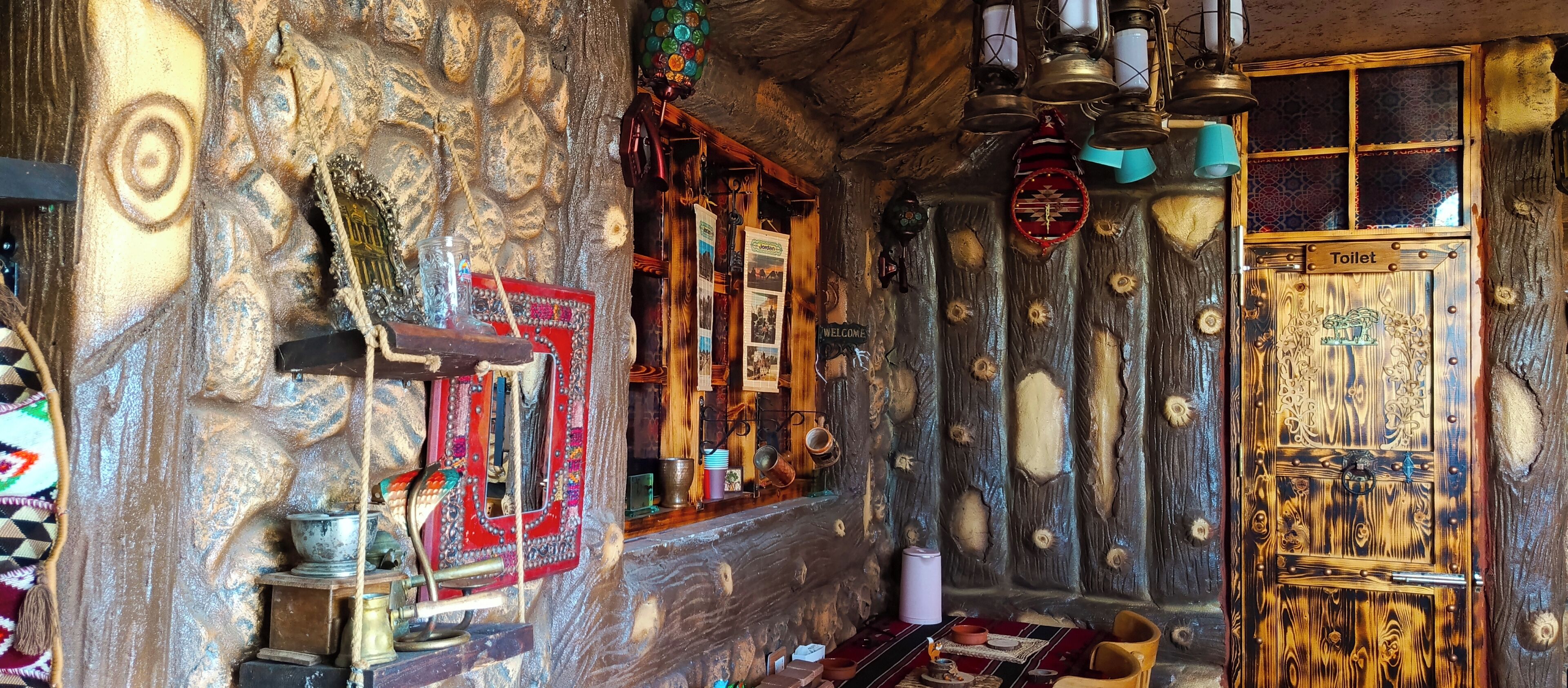 Un interno rustico con parete in pietra, porta in legno con la scritta 