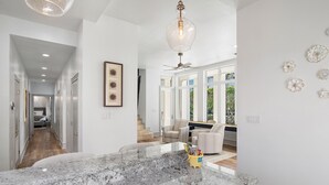 A spacious kitchen with a granite countertop, a ceiling fan, and a pendant light. - Private Heated Pool - Golf Cart Included (Destin)