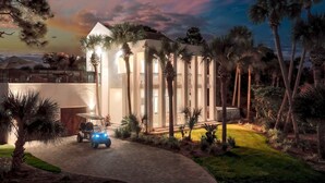 A modern house with a driveway, palm trees, and a golf cart. - Private Heated Pool - Golf Cart Included (Destin)