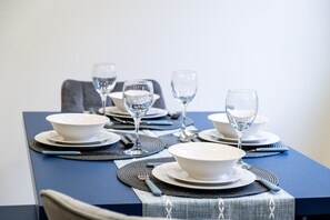 Enjoy meals with family and friends at this dining table, set for four with fine china and crystal glasses.