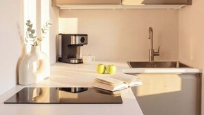 A modern kitchen with a coffee maker, sink, and a book on the counter.