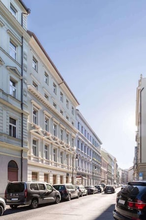 A street with parked cars and a row of buildings with classical architecture. - TurnKey | Republic Sq. Duplex II – with Terrace (Praha 1)