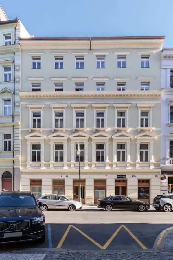 A multi-story building with a classical architectural style, featuring a central entrance with a large door and windows on each floor.